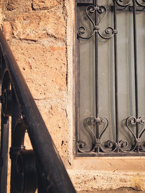 Free Close-up of a historic iron window on a stone wall in Corchiano, Italy. Stock Photo