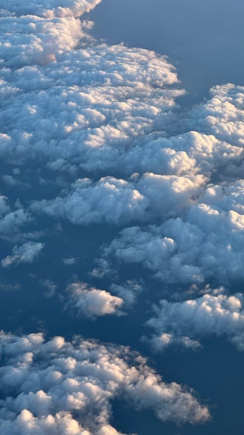 Free A peaceful aerial view capturing a field of fluffy white clouds against a blue sky. Stock Photo