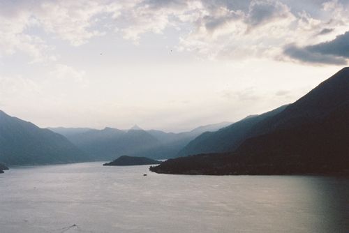 Free A tranquil mountain lake scene at twilight with soft lighting and clouds. Stock Photo