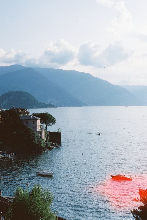 Free A serene view of Lake Como, Italy, with boats and a mountainous backdrop during the day. Stock Photo