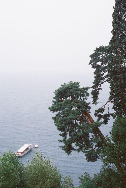 Free A peaceful view of a lake with lush trees and floating platform. Stock Photo
