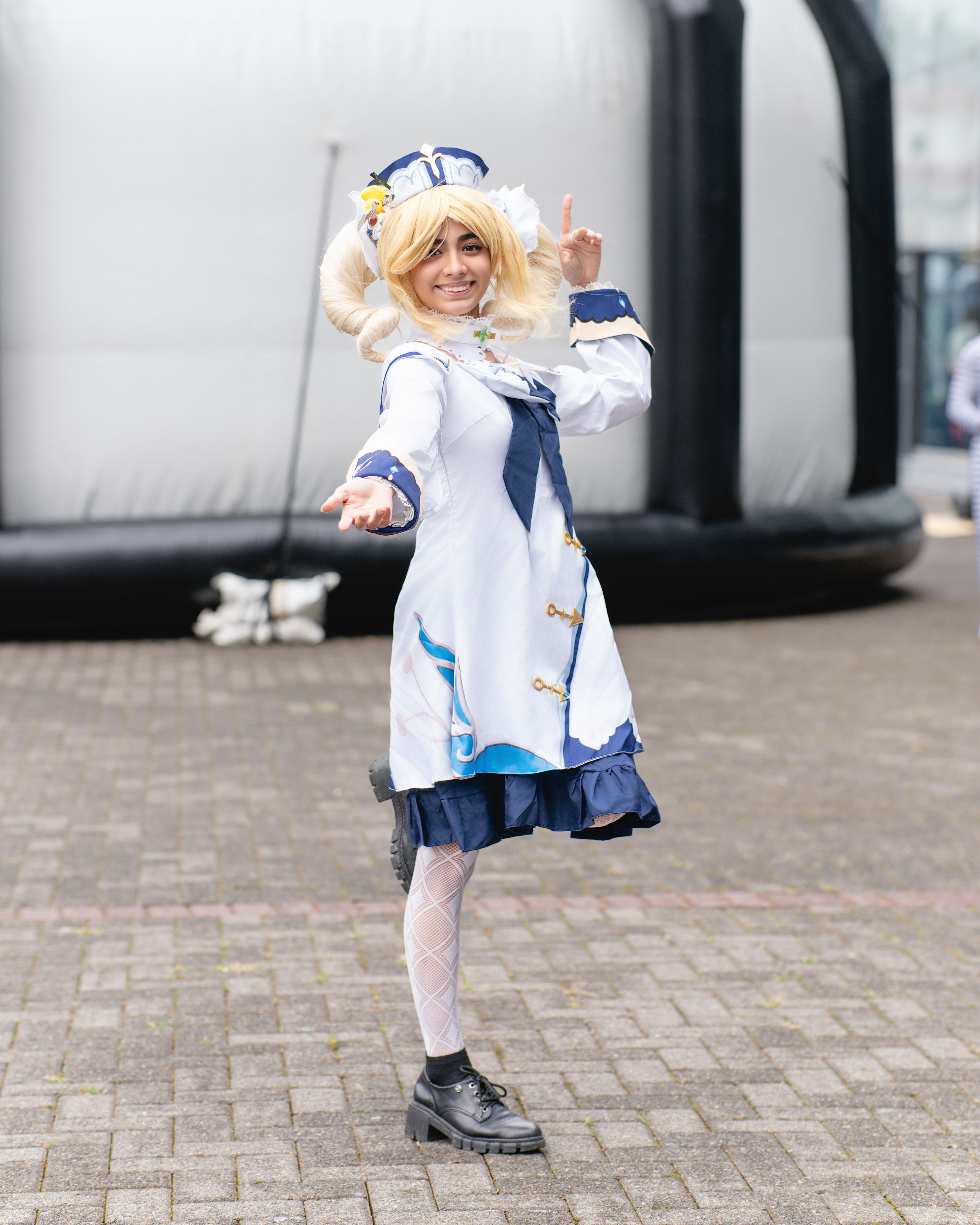 A cosplayer dressed in a detailed anime costume poses outdoors at an anime convention in San José, Costa Rica.