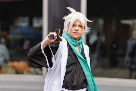 Anime cosplayer poses with costume and prop at a convention in San José, Costa Rica.