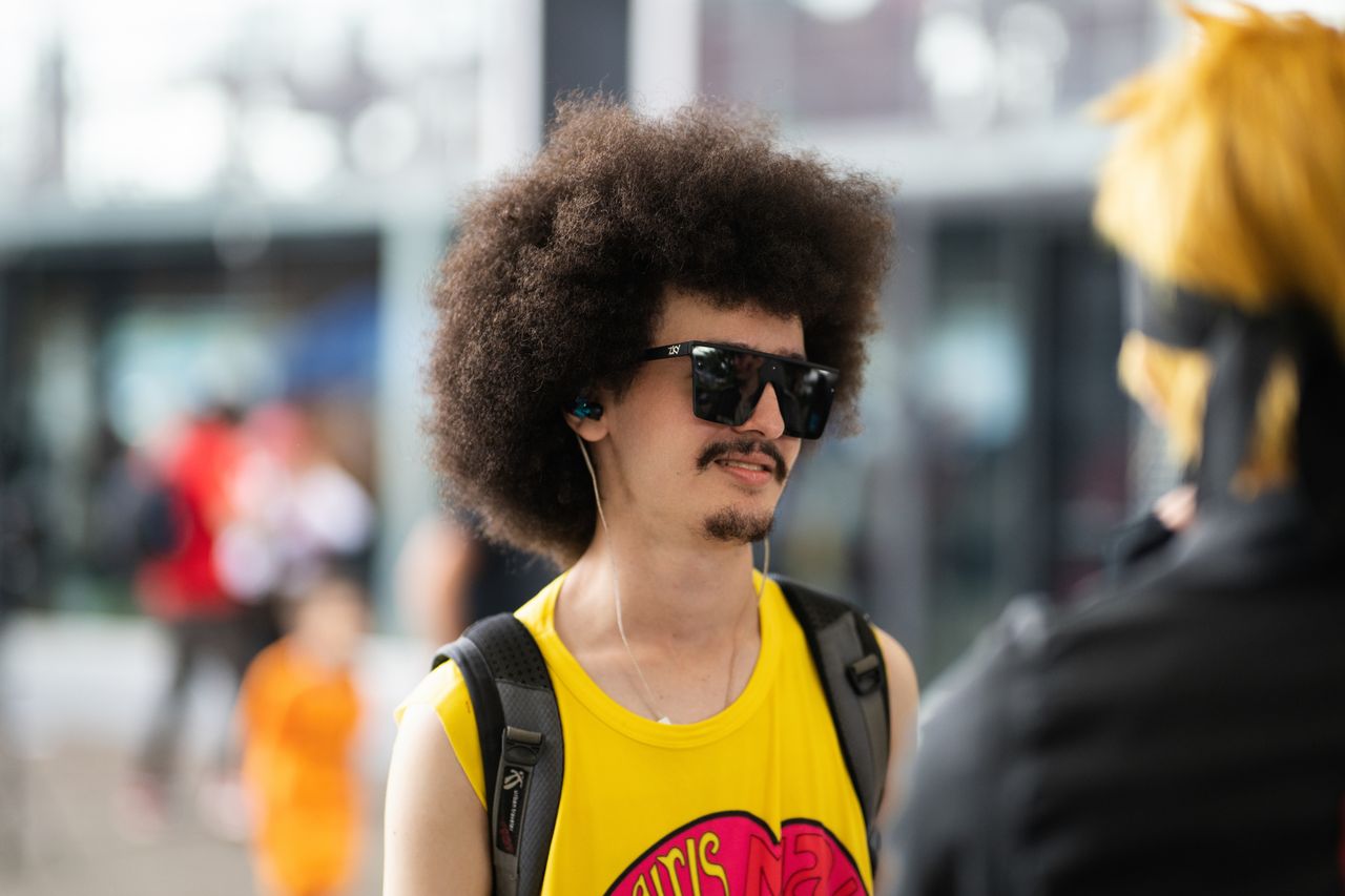 young man in anime costume with afro and sunglasses at a cosplay event