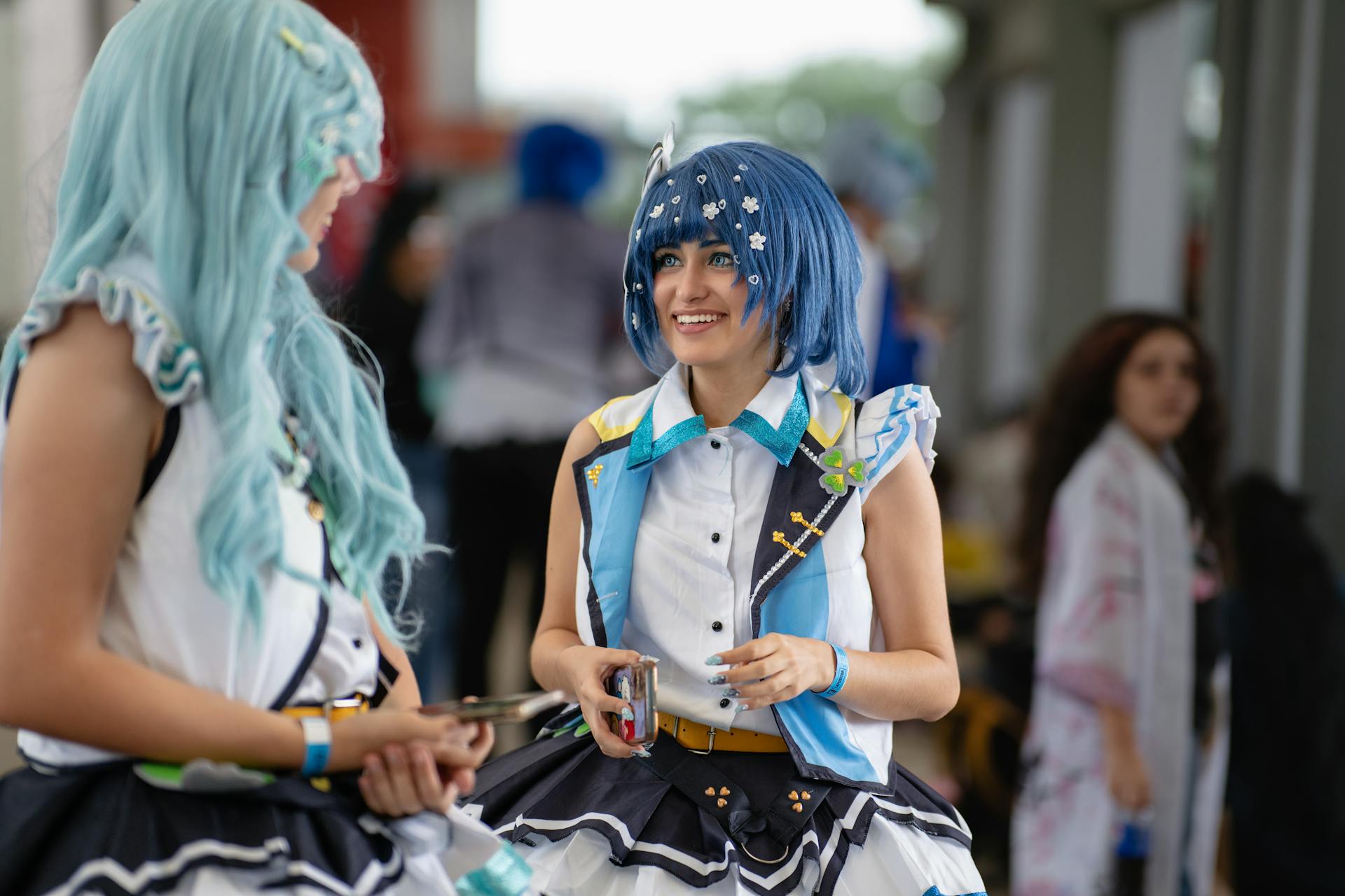 Two cosplayers in detailed costumes interact at an anime convention in San José, Costa Rica.