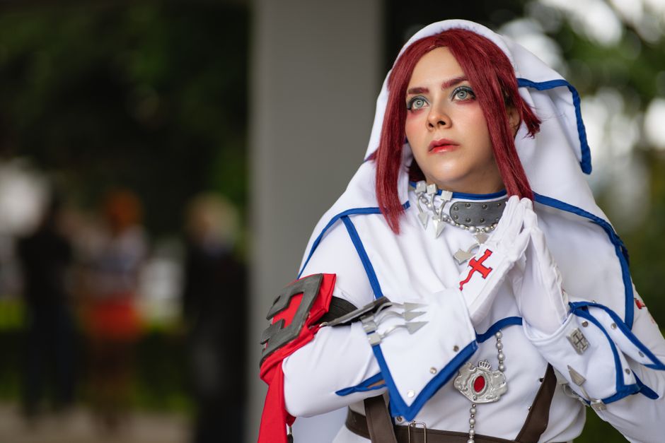 Cosplay artist dressed in intricate costume at a convention in San José.