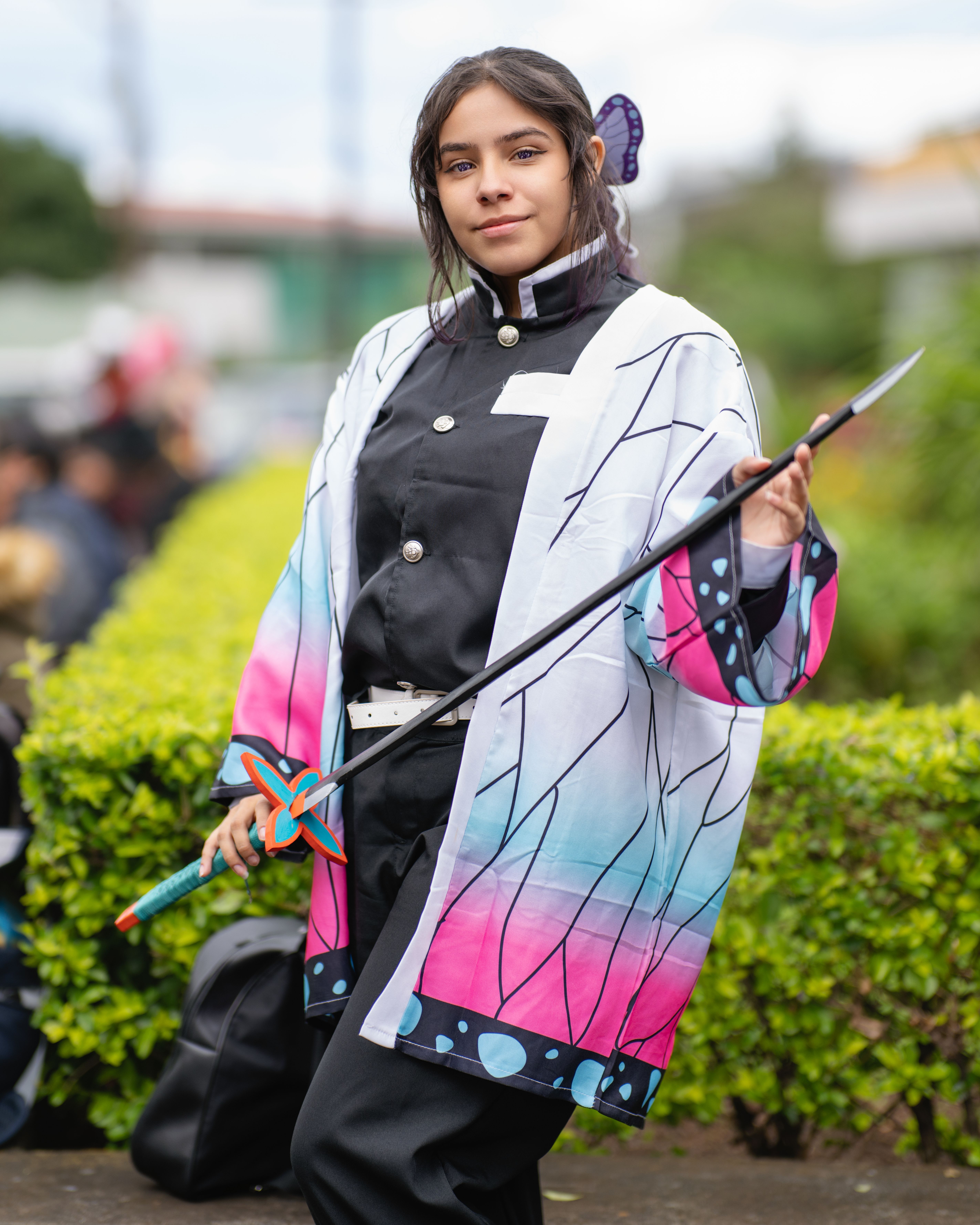 A cosplayer in vibrant anime costume poses during an outdoor event in San José, Costa Rica.