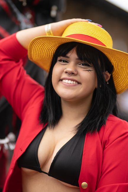 Smiling woman in anime cosplay with hat in San José, Costa Rica.