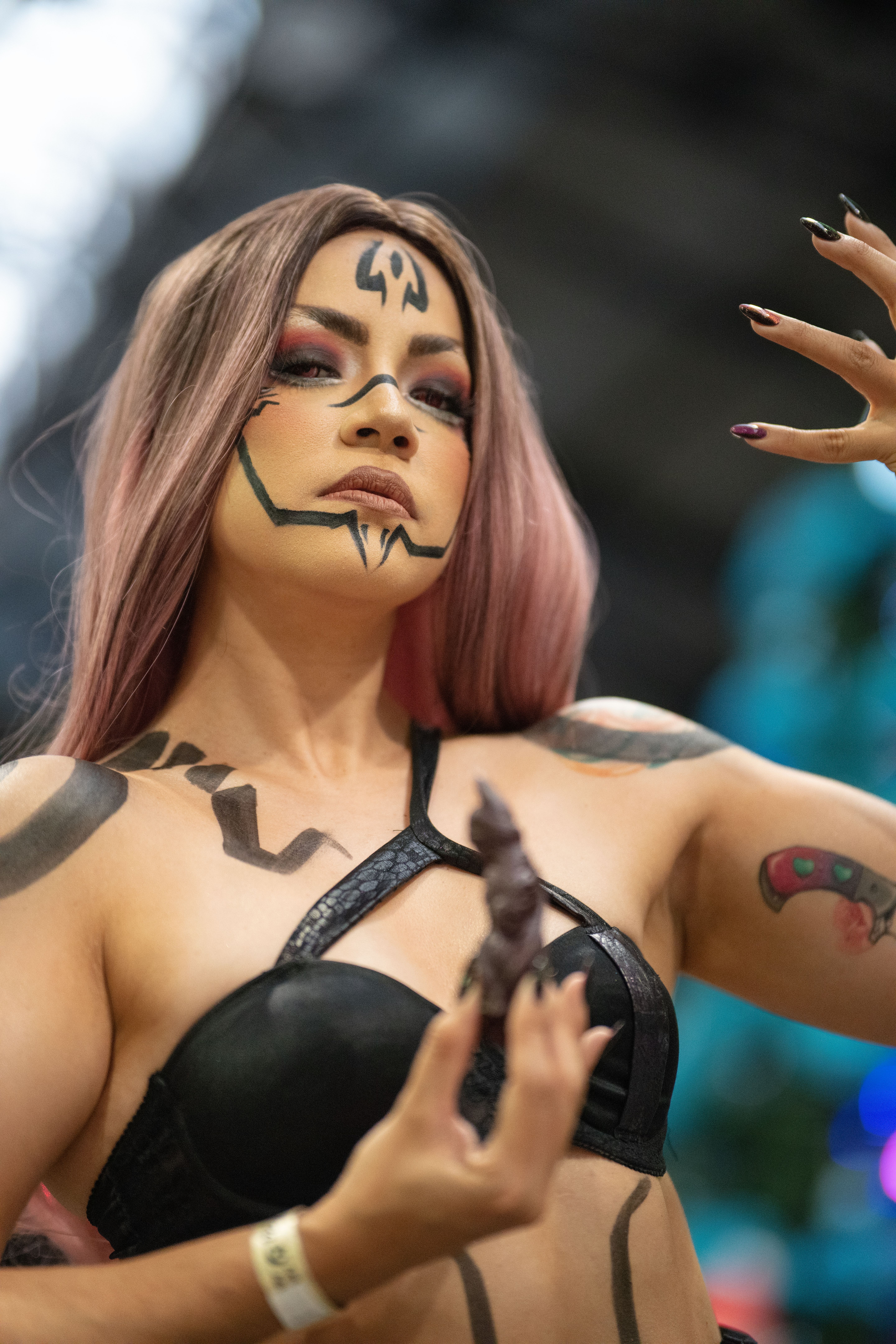 A captivating cosplay character with intricate face paint and striking pose at an anime event in Costa Rica.