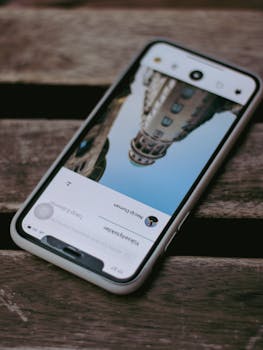 Smartphone showing a cityscape photo on its screen, placed on a wooden surface, artistic capture.