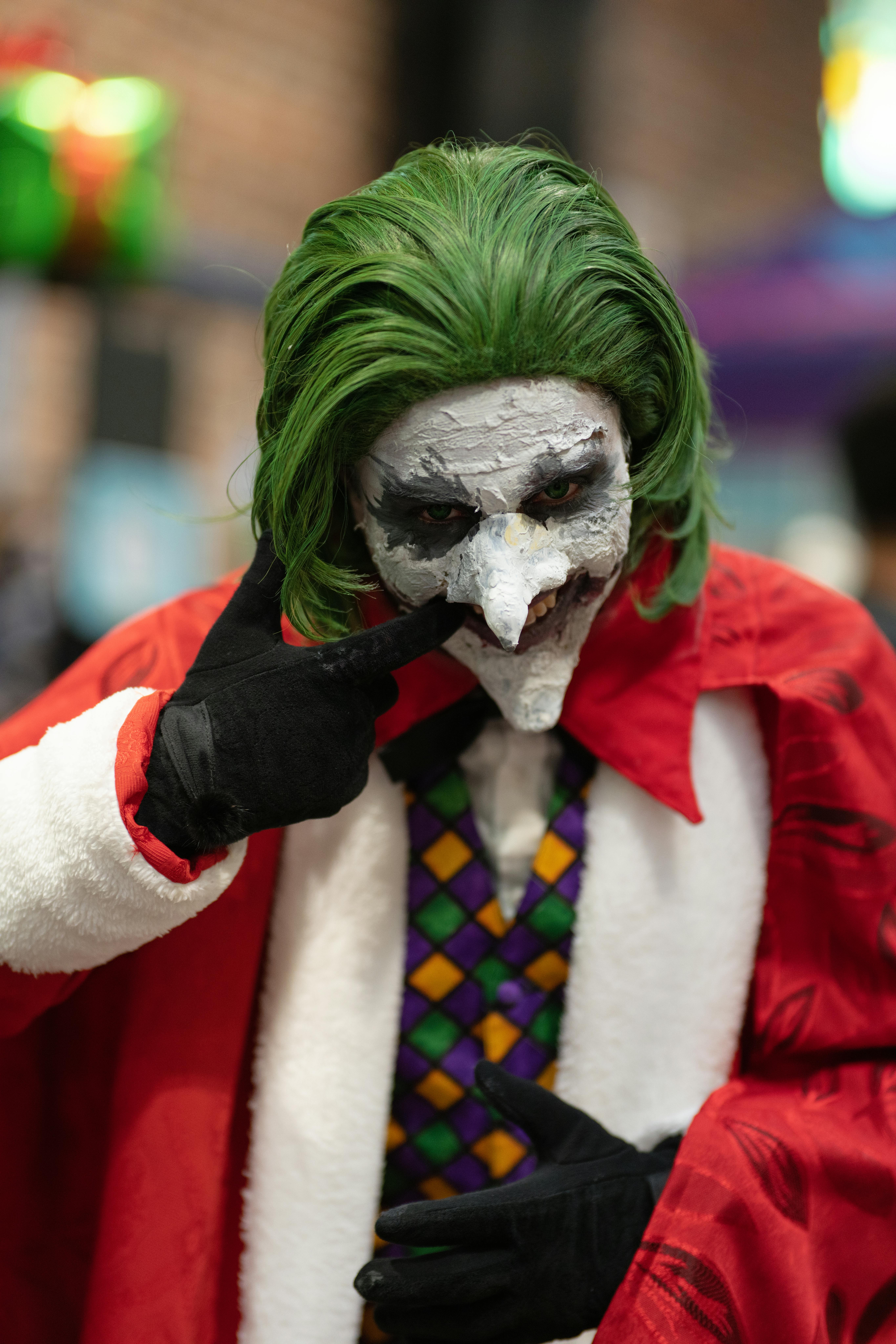 Colorful Joker-themed cosplay featuring a detailed face paint and classic green hair outdoor.