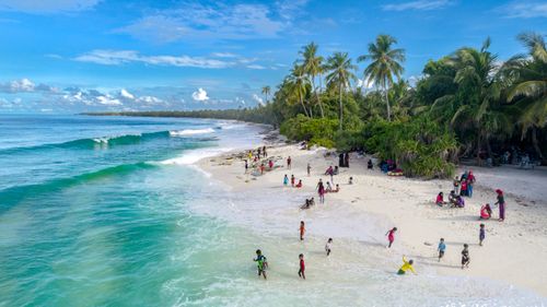 Free A vibrant tropical beach scene with people enjoying the sun and surf in the Maldives. Stock Photo