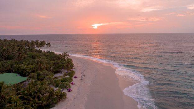 Aerial view of a tranquil Maldivian beach during a stunning sunset.