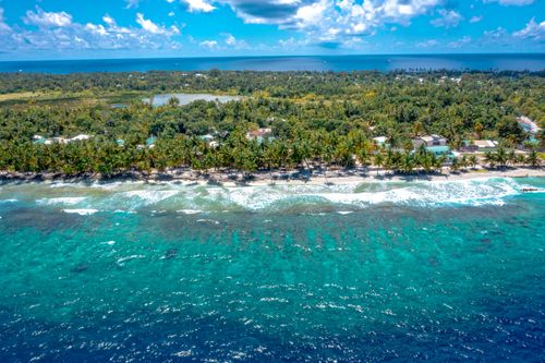 Free Stunning aerial view of a tropical island coastline with turquoise waters and lush greenery in the Maldives. Stock Photo