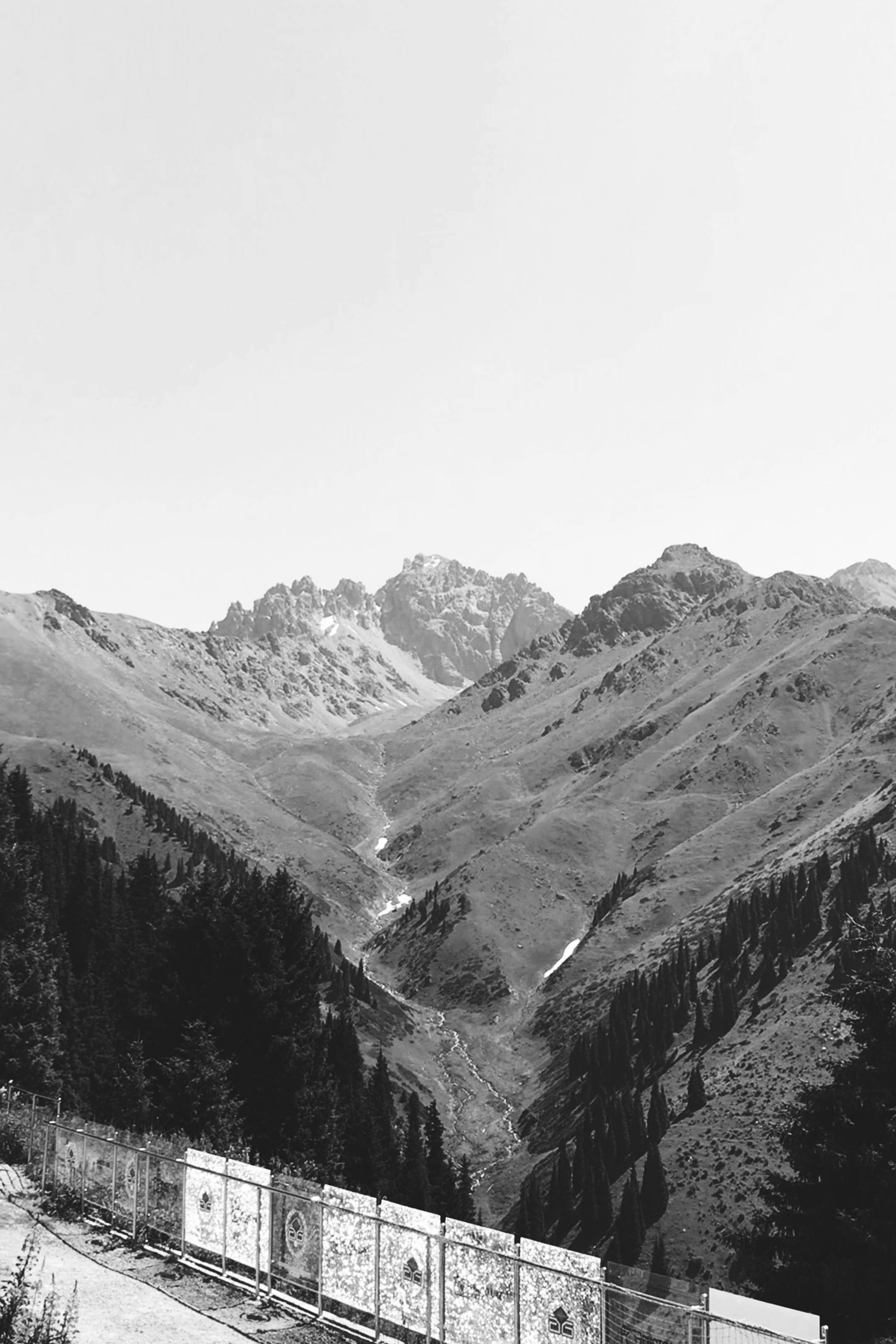 Black and white photo of Talgar mountains in Kazakhstan, showcasing rugged peaks and serene valleys.