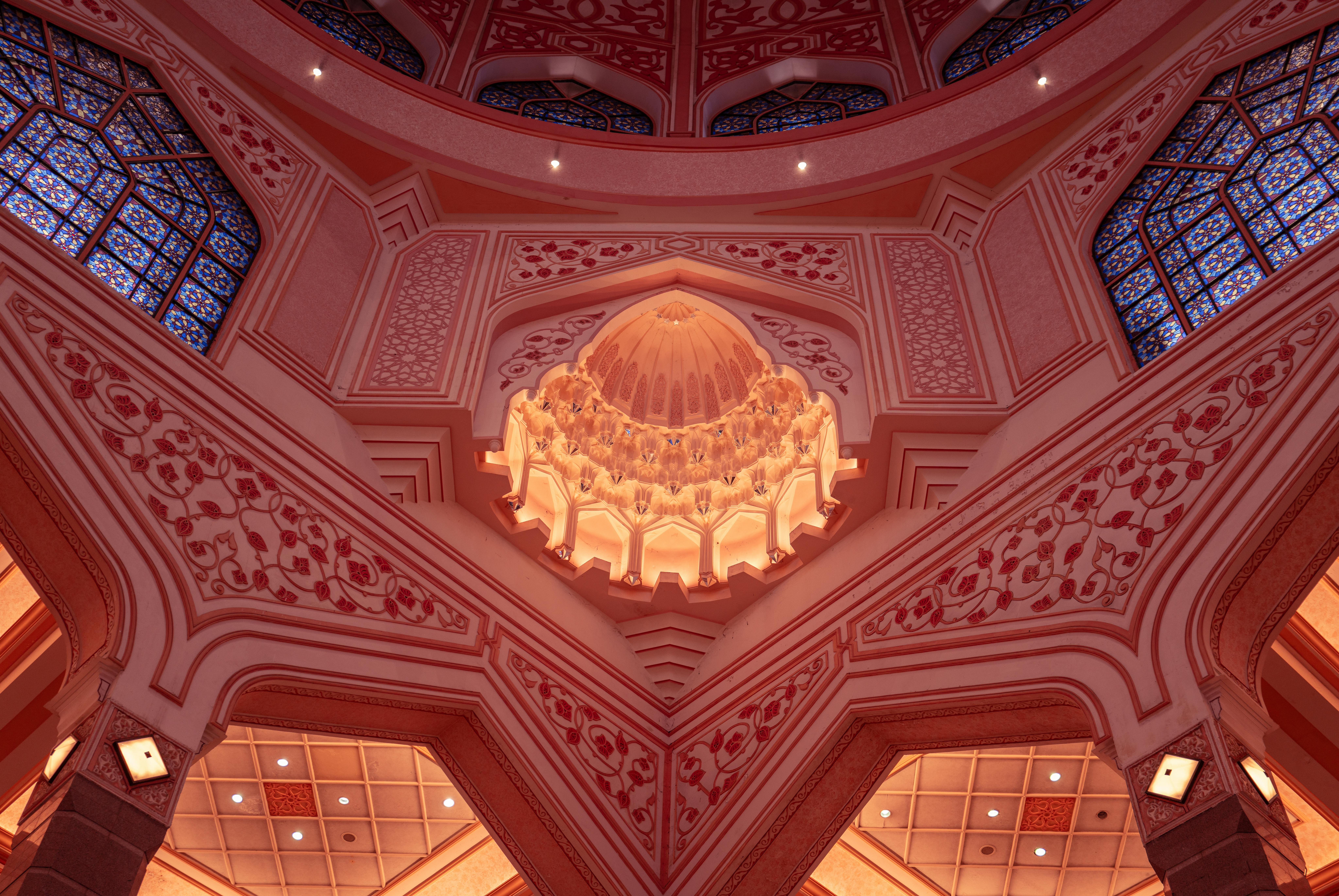 Stunning pink dome interior of Putra Mosque in Putrajaya, Malaysia showcasing Islamic architecture.
