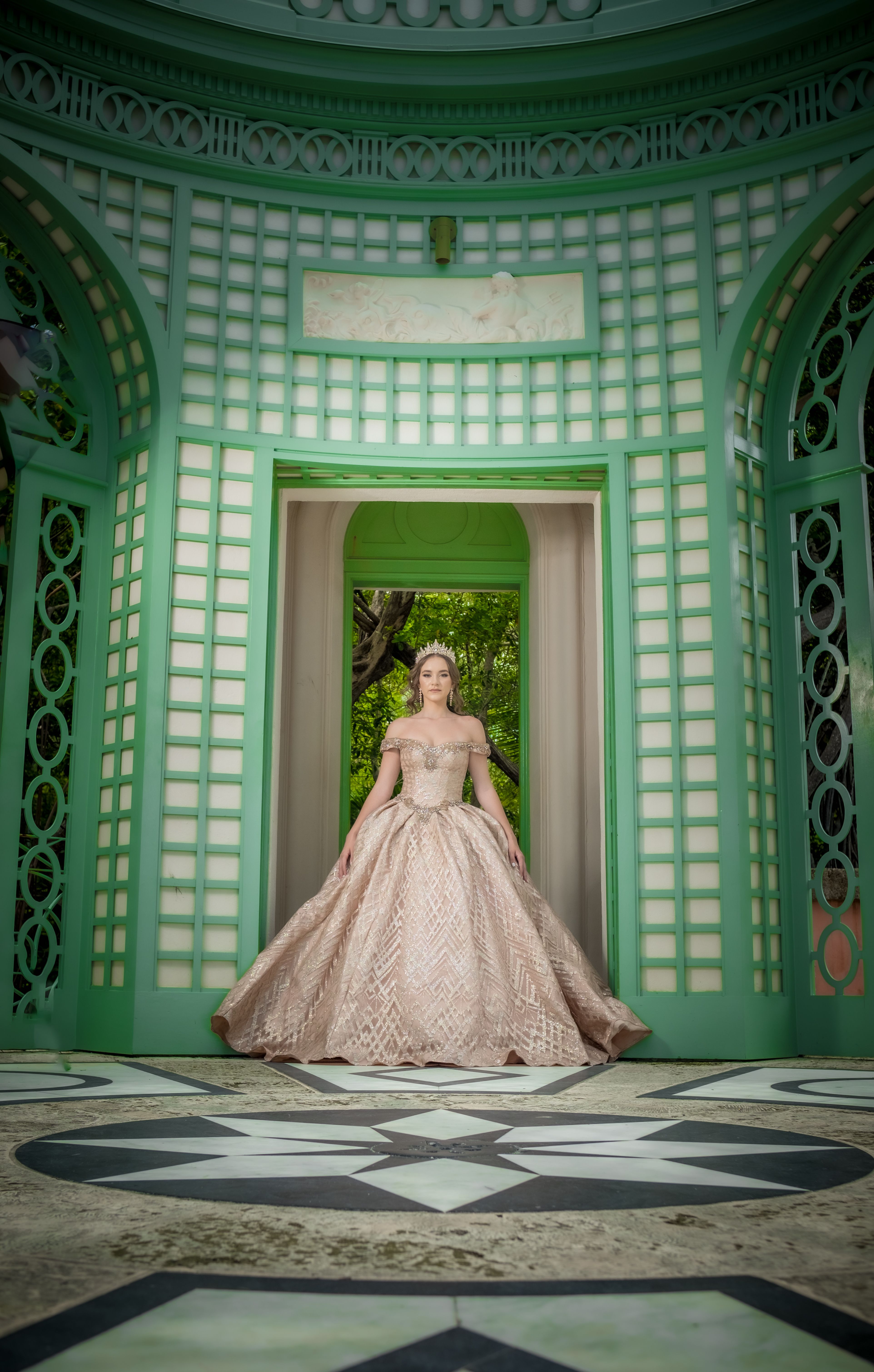 Elegant Woman in Luxurious Gown at a Green Pavilion · Free Stock Photo