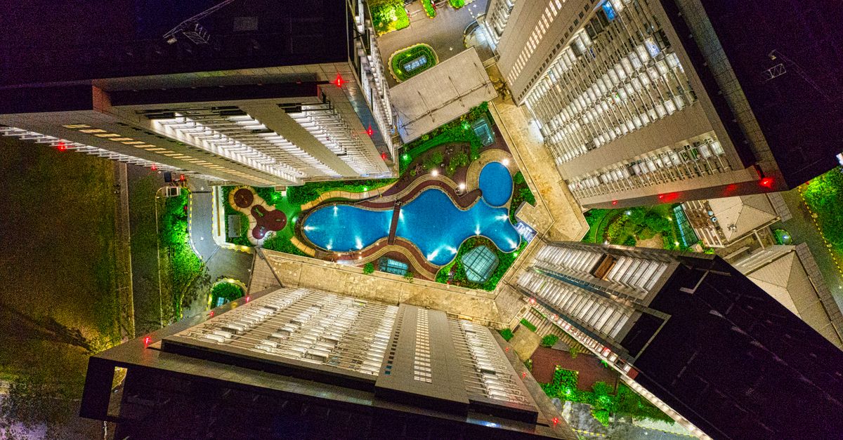 Aerial view of illuminated modern buildings and pool in Banten, Indonesia at night.