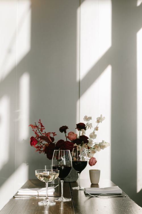 Free A beautifully set dining table with wine glasses and floral arrangement, perfect for a romantic setting. Stock Photo