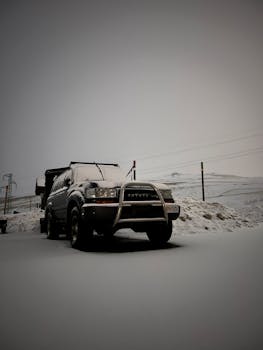 An SUV parked on a snowy road in Grau Roig, Andorra, during winter.