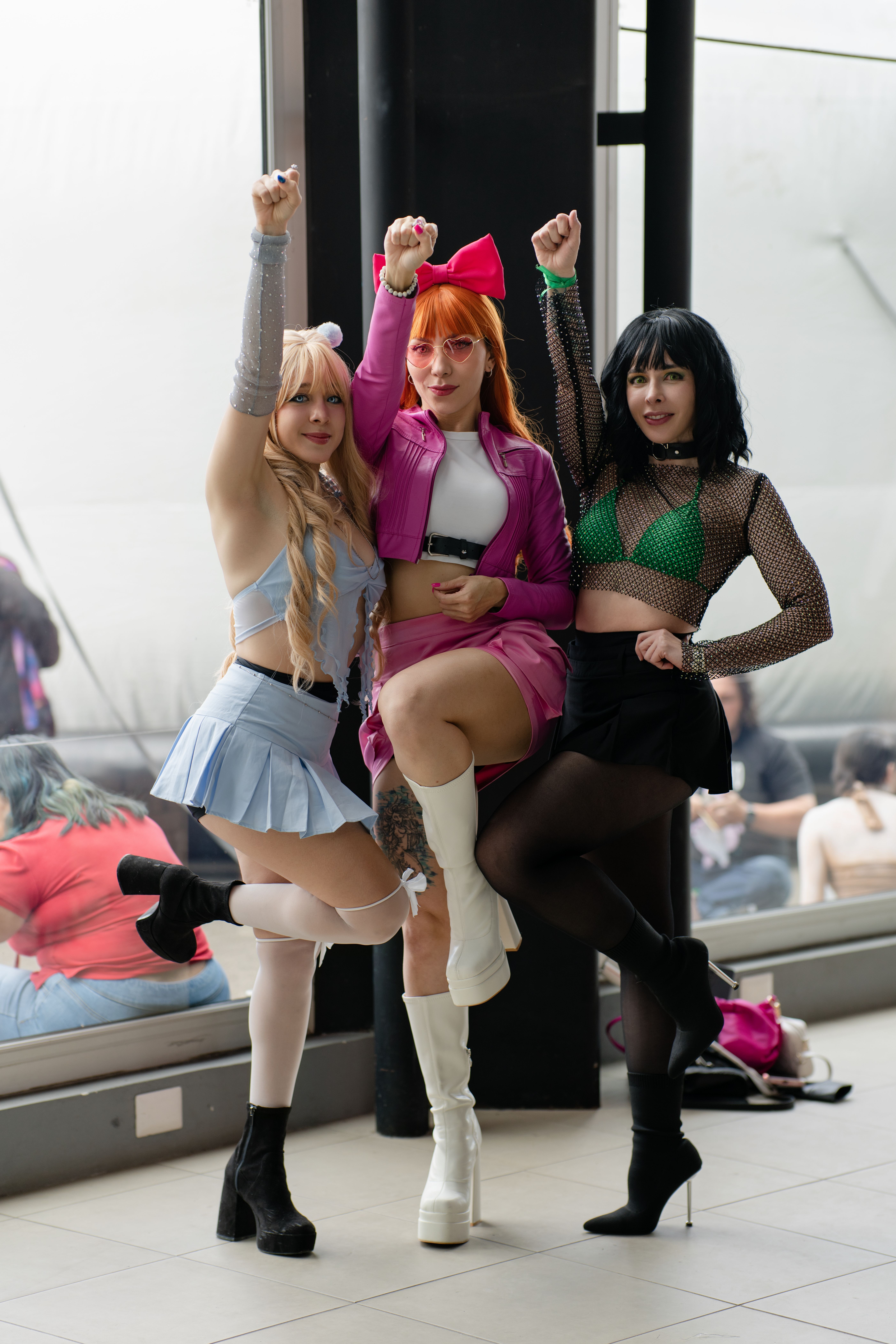 Three cosplayers striking a dynamic pose at an anime convention in San José, Costa Rica.