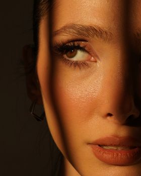 Dramatic close-up portrait of a woman with strong shadow play on her face.