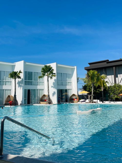 Free Stunning view of a beach resort with a clear blue sky and poolside relaxation in Pattaya, Thailand. Stock Photo