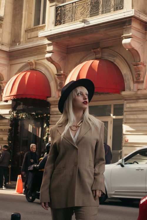 Free Stylish woman in a suit with a hat walking past Istanbul architecture in daylight. Stock Photo