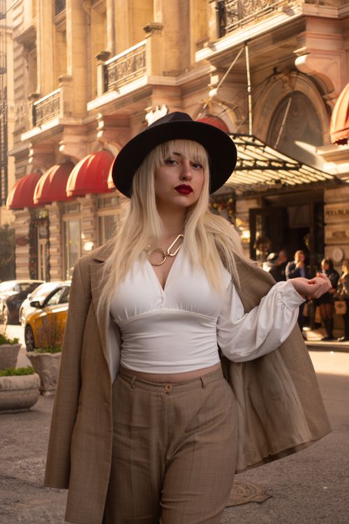 Free Stylish woman in Istanbul wearing a chic hat and beige suit. Capturing urban elegance. Stock Photo