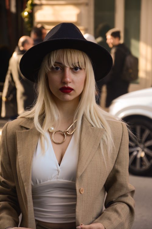 Free Fashionable woman in hat and blazer standing on a busy Istanbul street. Stock Photo