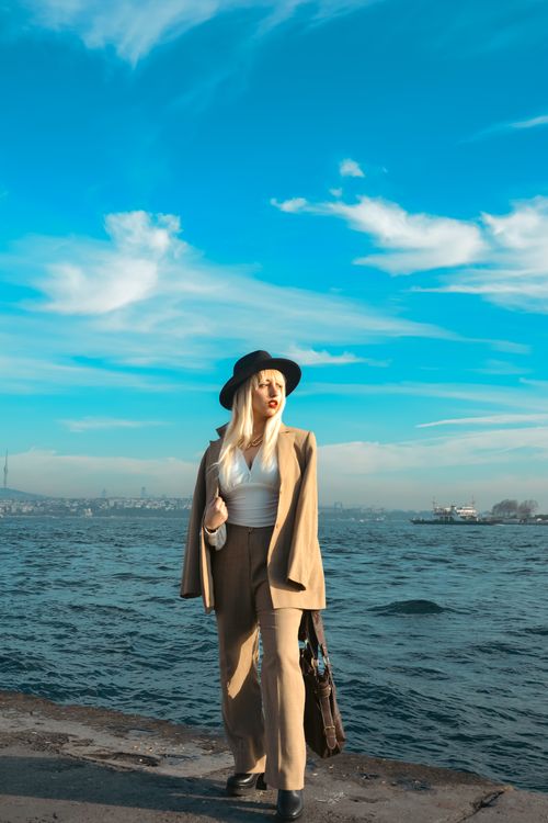 Free A fashionable woman in a beige suit stands by the Bosphorus in Istanbul, Türkiye. Stock Photo