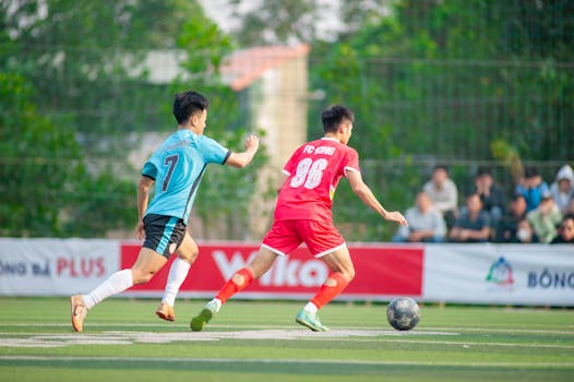 Two soccer players compete passionately in Hanoi, showcasing vibrant local sports culture.