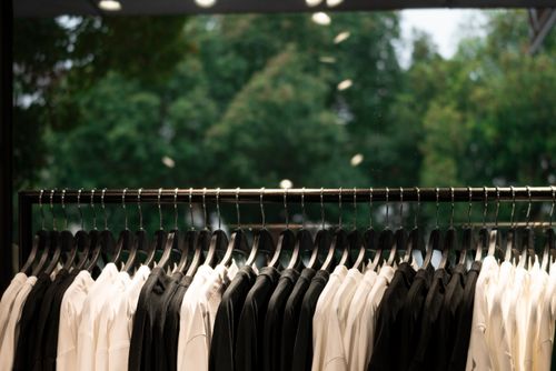 Rail of black and white shirts in a shop — photo by Star Zhang on Pexels