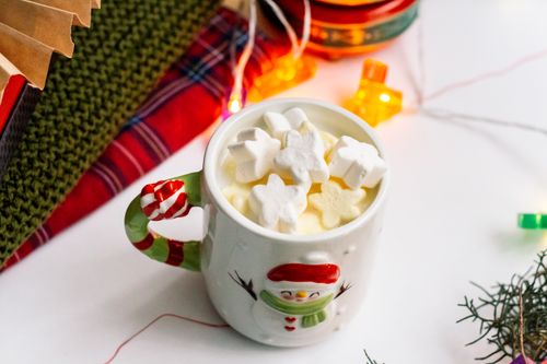 Free Cozy holiday hot chocolate with star-shaped marshmallows in a festive mug, surrounded by Christmas decor. Stock Photo