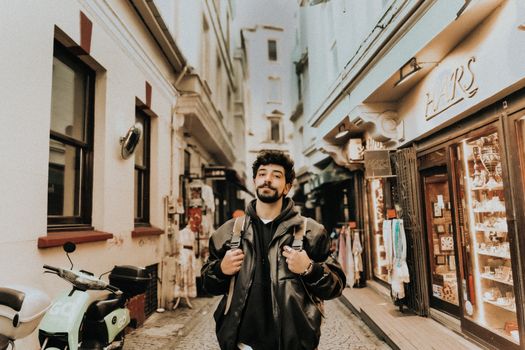 Casual young man with backpack strolling through vibrant Istanbul market.