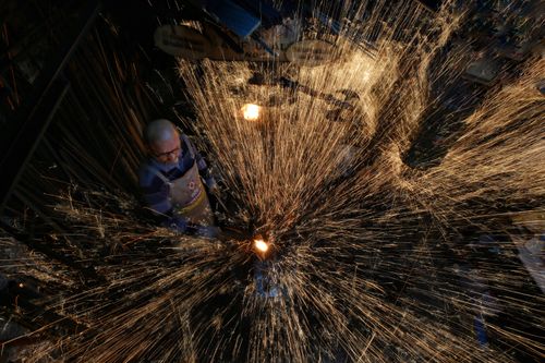 Free An aerial view of a blacksmith at work with vibrant iron sparks illuminating the workshop in Karabük, Türkiye. Stock Photo