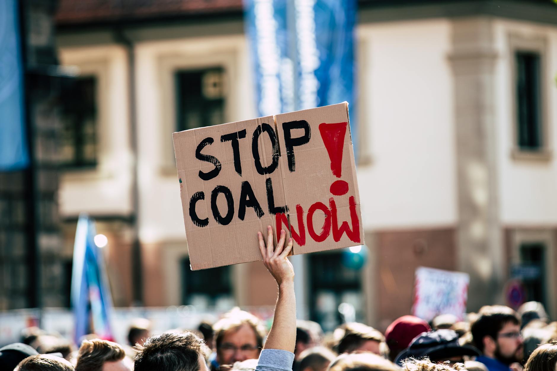 People protesting with a Stop Coal Now sign