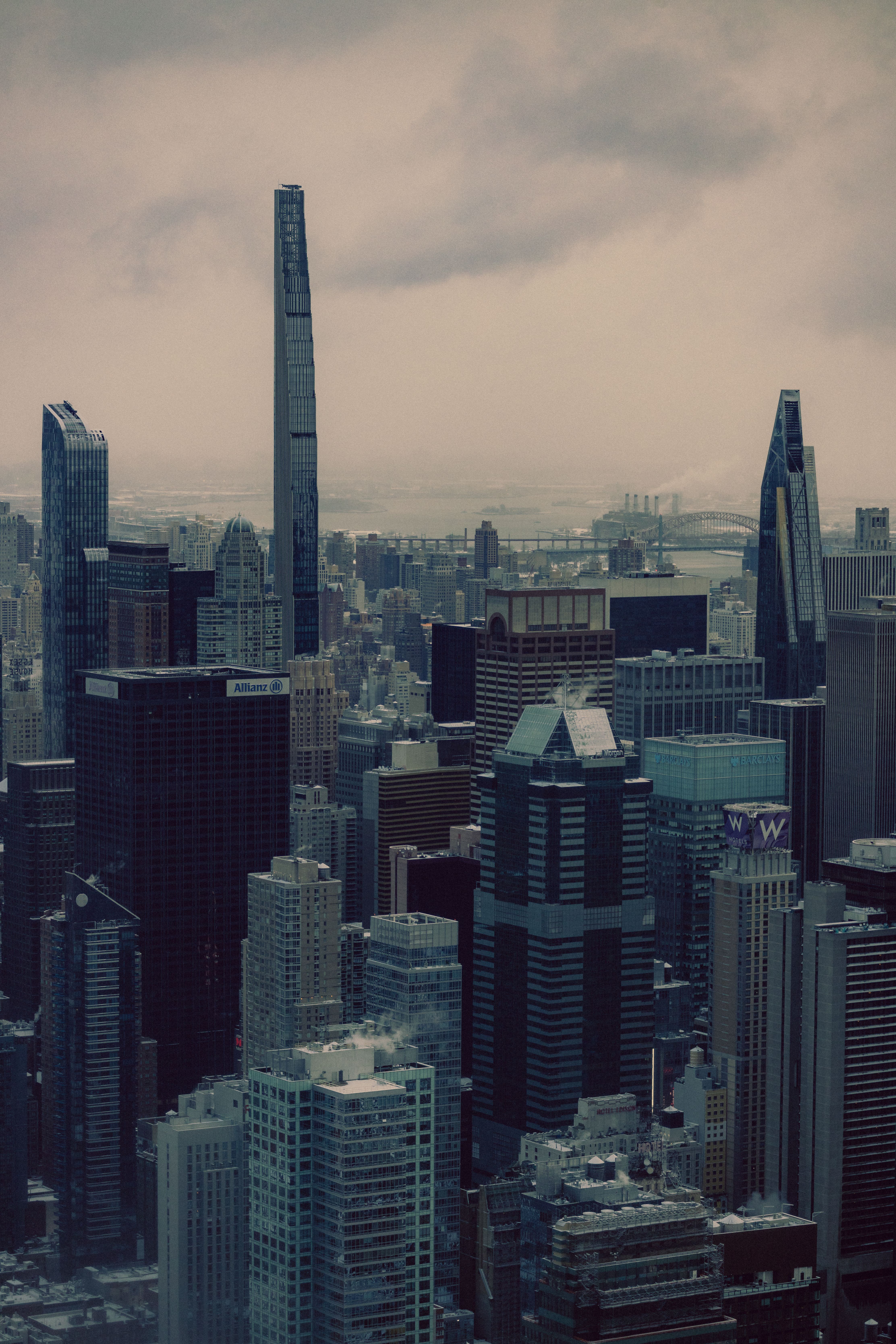 Dramatic view of Manhattan skyscrapers under an overcast sky, capturing urban architecture.