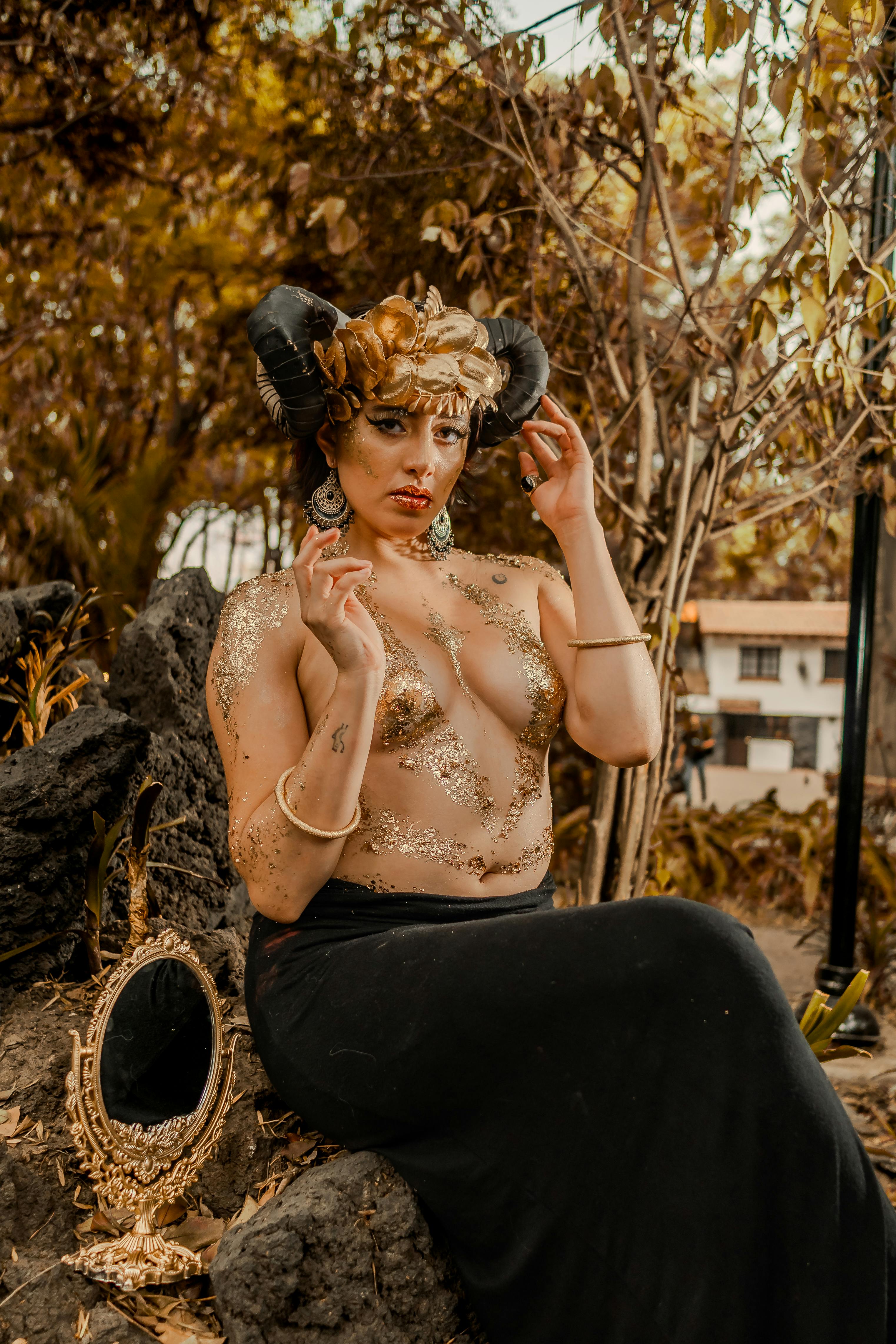 grátis Retrato surreal encantador de uma mulher com capacete de chifre em um cenário místico ao ar livre. Foto profissional