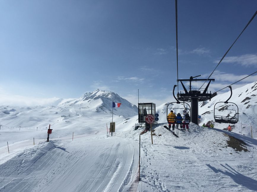 Scenic view of a ski lift in Tignes, French Alps, with skiers in winter.