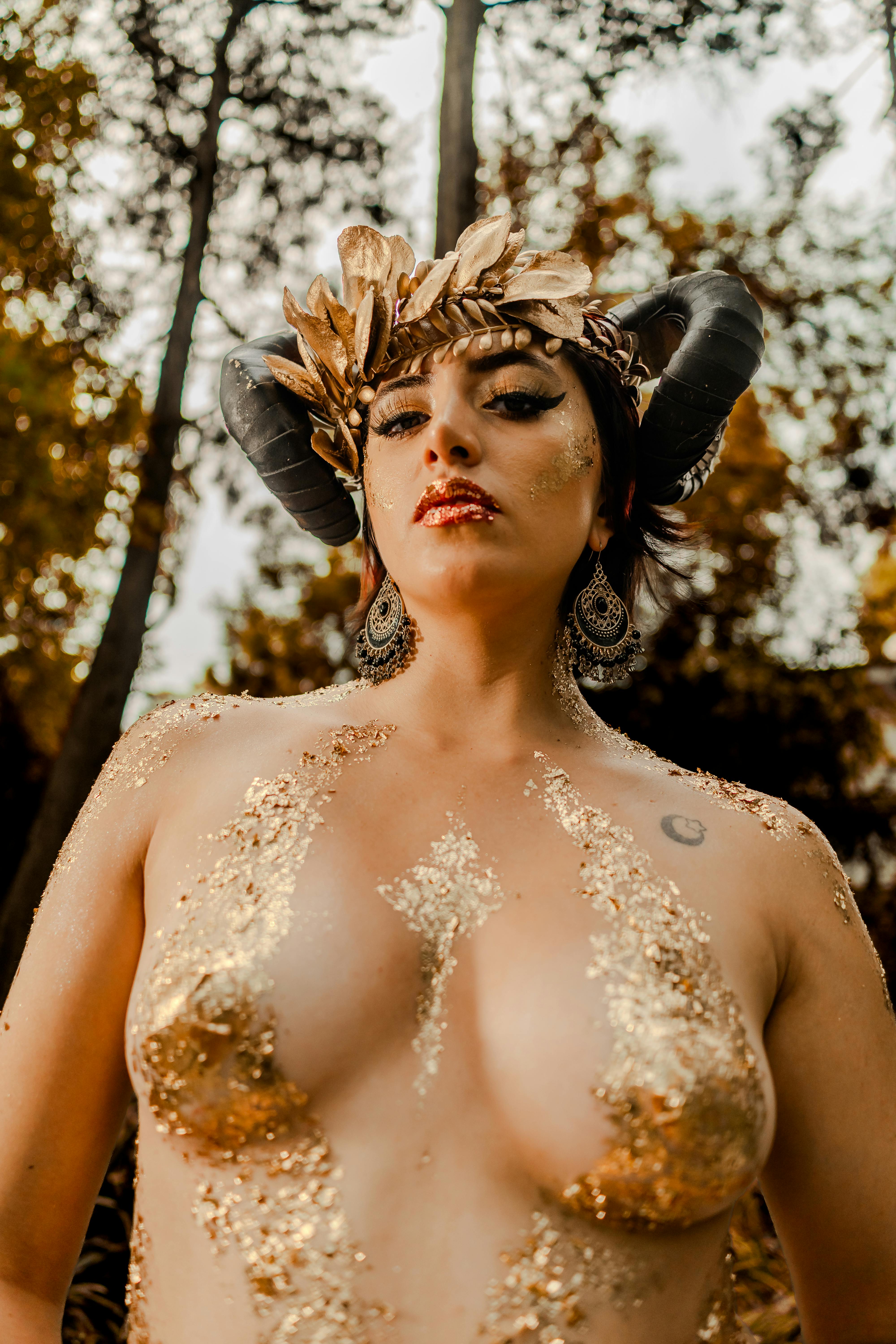 Gratuit Portrait surréaliste d'une femme au maquillage métallique et à la coiffe à cornes dans un décor fantastique en plein air. Photos