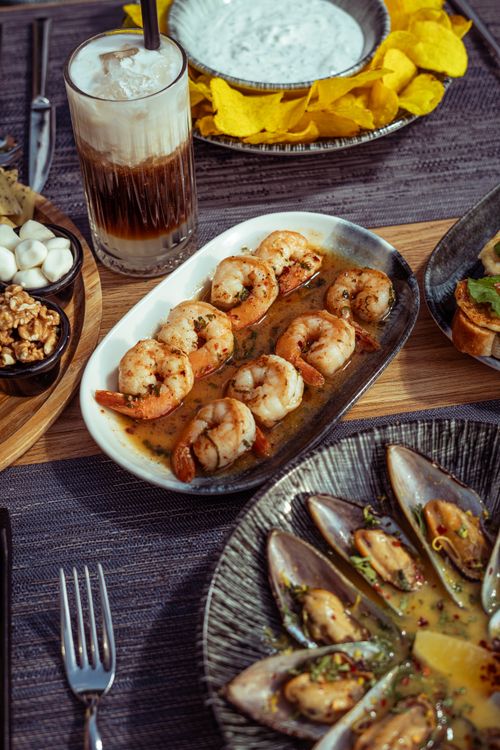 Free A diverse spread featuring shrimp, mussels, snacks, and a cold beverage, perfect for a gourmet dining experience. Stock Photo
