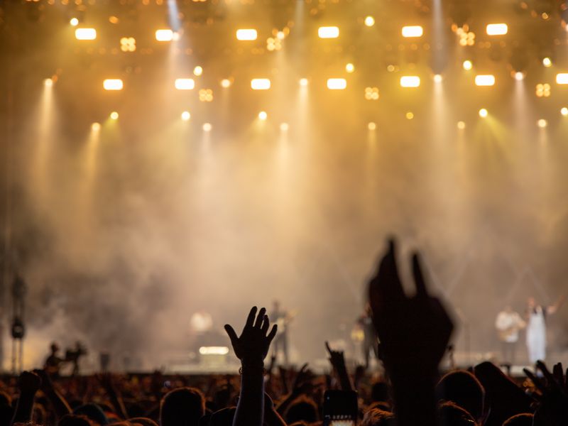 A lively crowd at an evening event under stage lights