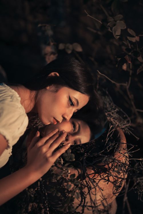 Free A woman gazes into a mirror in a forest setting, creating a mysterious and artistic ambiance. Stock Photo