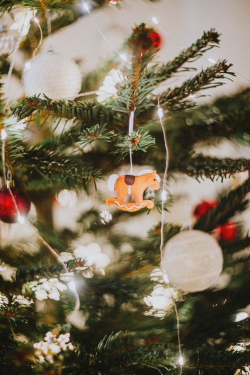 Free Beautifully decorated Christmas tree with warm lights and traditional ornaments. Stock Photo