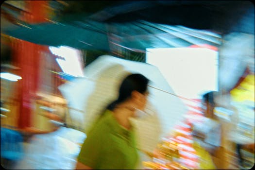 A vibrant, blurred image of a bustling street scene in Bangkok displaying urban movement.