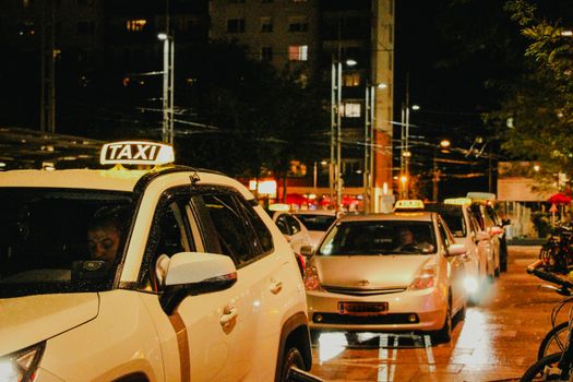 Taxis lined up under streetlights in Salzburg, Austria, captured at night.