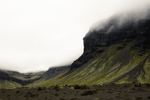 Free Dramatic mist-covered mountains in Iceland's rugged highlands, showcasing vibrant green slopes. Stock Photo