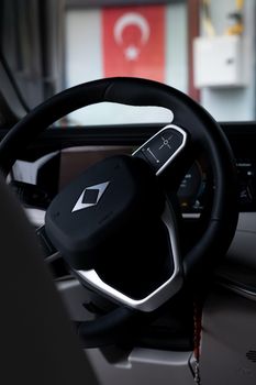 Car steering wheel with a visible Turkish flag in the background, offering a sense of location and culture.
