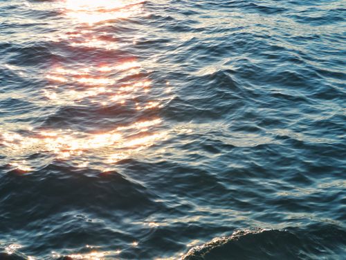 Free Captivating image of ocean waves reflecting sunlight, creating a sparkling effect on the water surface. Stock Photo